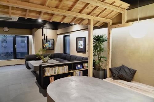 a living room with a couch and a table at MATSUMOTO CASTLE hostel in Matsumoto