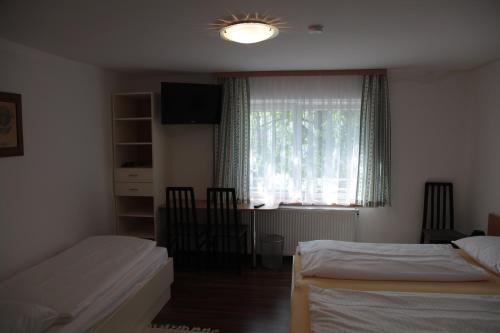ウィーナー・ノイシュタットにあるPension Casa Topolinoのベッドルーム1室(ベッド2台、窓付)