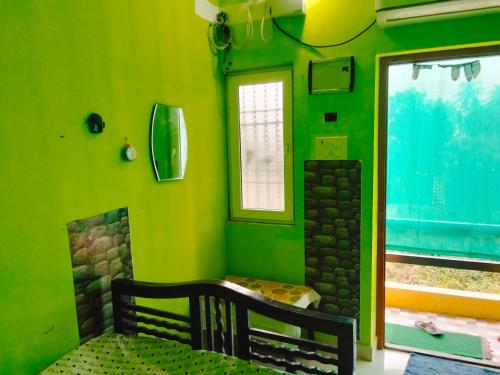 a green room with a bench and a fireplace at ThendralHomeStay in Pondicherry