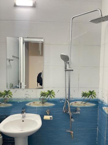 a bathroom with a sink and a shower with palm trees at Anna's House - Hoa Lư in Ninh Binh