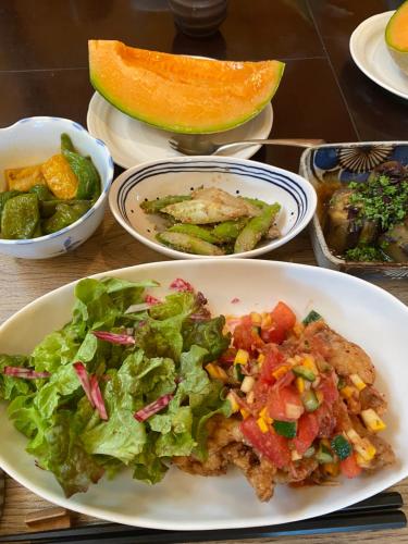 a table with a plate of food and a salad at Yubari Forest Farm BandB in Yubari