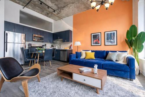 a living room with a blue couch and a kitchen at Cozy 2BR South Loop Condo with Optional Parking and Gym Near McCormick Place, Public Transit & City Hotspots in Chicago