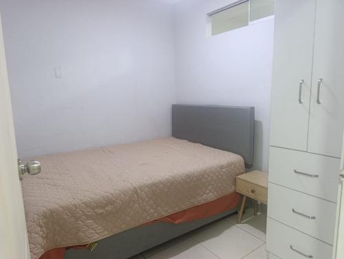 a small bedroom with a bed and a cabinet at Minidepartamento Centro de Huanuco in Huánuco