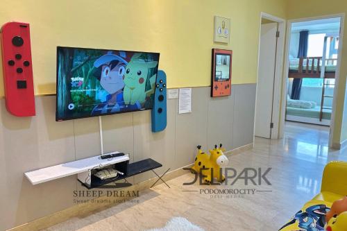 a living room with a flat screen tv on a wall at SheepDream 7DI DeliparkMall 2Bedroom, 1Bathroom in Medan