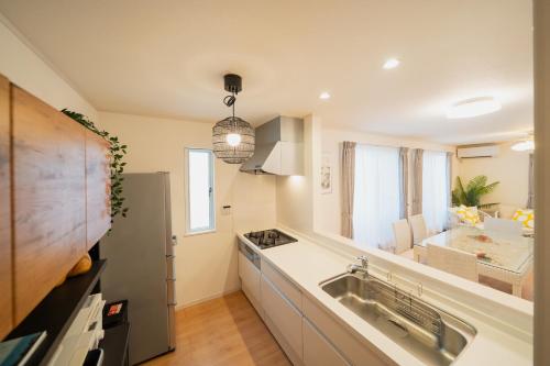 a kitchen with a sink and a counter at 照間Terumaの美しい海Mareまで徒歩30秒リビング広々快適 TERUMAREテルマーレ in Uruma