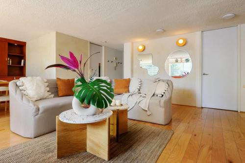 a living room with a couch and a table with a plant at Amazing TERRAZO place, 8 guest!! 4 beds in Mexico City