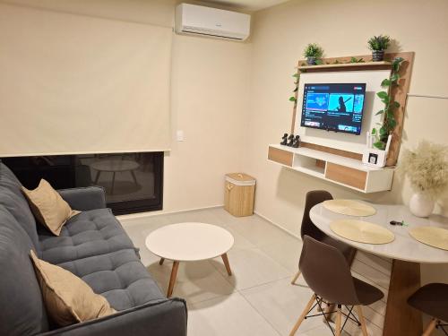 a living room with a couch and a tv and a table at Dpto Resort zona aeropuerto in Luque