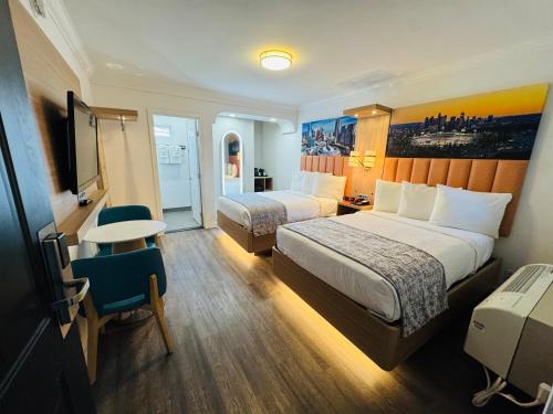 a hotel room with two beds and a table at The Lexmar - Dodger Stadium Hollywood in Los Angeles