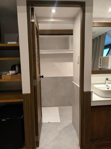 a bathroom with a sink and a mirror and a door at Casitas de Boracay in Boracay