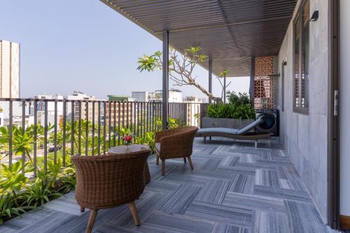 a patio with chairs and a table on a balcony at Ciao Boutique Danang - New Hotel Opening April 2026 in Danang