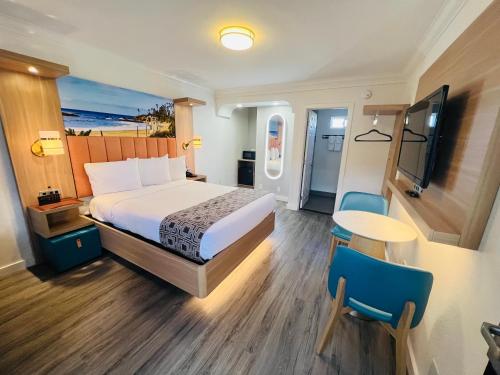 a hotel room with a bed and a table and chairs at The Lexmar - Dodger Stadium-Convention Center in Los Angeles