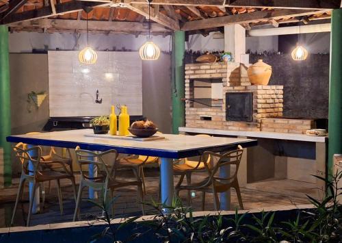 a table and chairs in a kitchen with lights at Berlinque Pet Friendly - Muito espaço perto do mar in Vera Cruz de Itaparica