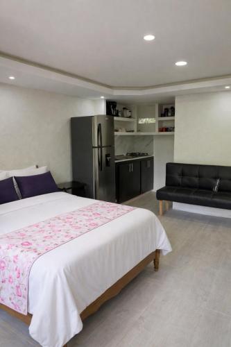 a bedroom with a bed and a refrigerator and a couch at Refugio Rio Santo in Las Alfombras