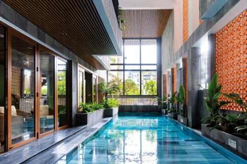 a pool in the middle of a building with plants at Ciao Boutique Danang - New Hotel Opening April 2026 in Danang