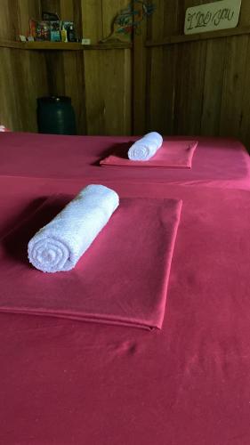 two beds with pink sheets with towels on them at Amaca Eco Station in Iquitos