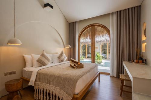 a bedroom with a large bed and a bathroom at Bebas Suites - Uluwatu, Bali in Uluwatu