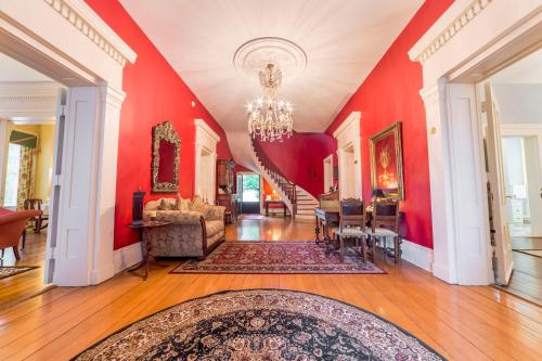 a living room with red walls and a chandelier at Bourbon Manor Bed & Breakfast Inn in Bardstown