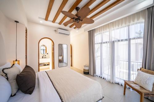 a bedroom with a bed and a ceiling fan at Villa Arco Pererenan in Canggu