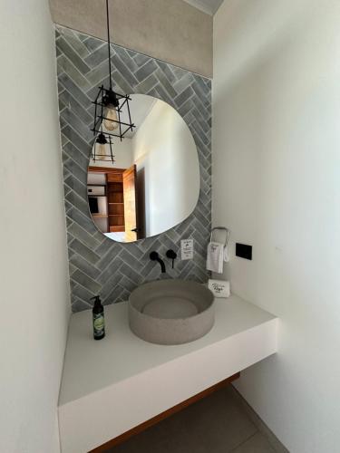 a bathroom with a sink and a mirror at Roys Suites Galapagos in Puerto Ayora