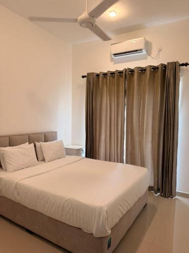 a bedroom with a bed and a window with curtains at Luxury Golf and Relaxation in Gonapola