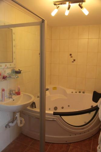 a bathroom with a tub and a sink at Pension Casa Topolino in Wiener Neustadt