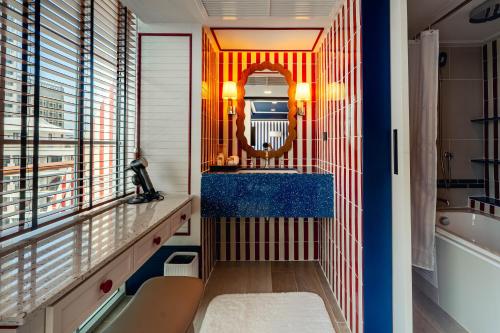 a bathroom with a tub and a sink and a mirror at The Cruise Hotel in Pattaya