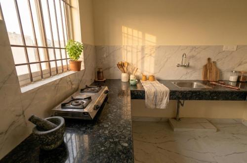 a kitchen with a stove and a sink at Greenwood stay in Bhilai