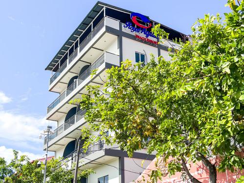 a white building with a red sign on it at Royal Agate Beach Resort in Pantai Cenang
