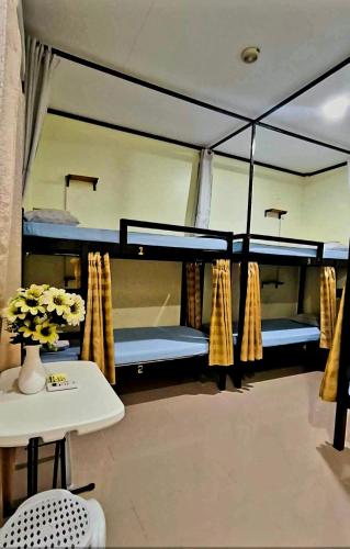 a room with three bunk beds and a table at CheRi Backpackers Hostel in Moalboal