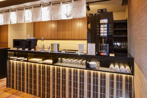 a bar in a restaurant with a coffee machine at Yamatoya Honten Ryokan Osaka in Osaka