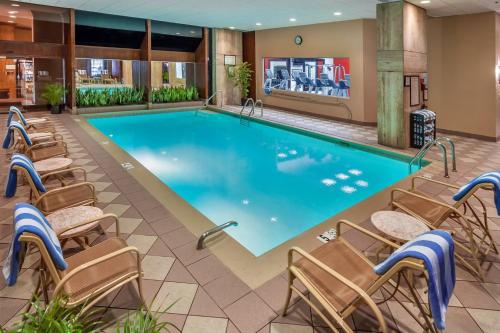 a pool in a hotel room with chairs around it at DoubleTree by Hilton Philadelphia Airport in Philadelphia