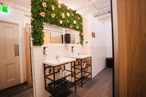 a bathroom with two sinks and ivy on the wall at Tequila Sunrise Hostel Adelaide in Adelaide