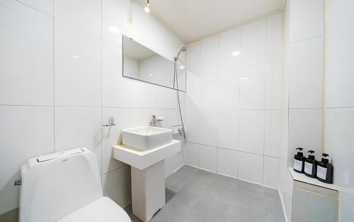 a white bathroom with a toilet and a sink at Bucheon The Seollelm Hotel Stay in Bucheon
