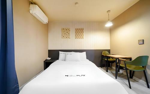 a bedroom with a bed and a desk and a table at Bucheon The Seollelm Hotel Stay in Bucheon