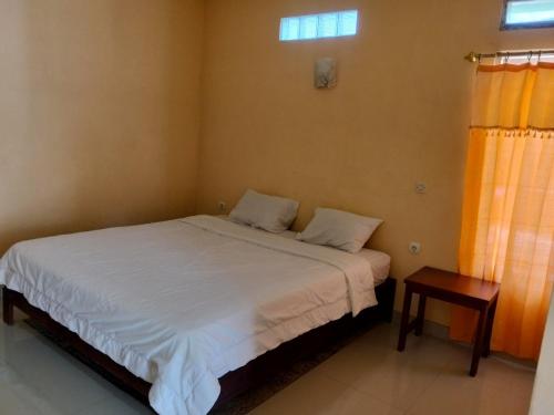 a small bedroom with a bed and a table at Irene in Kelimutu
