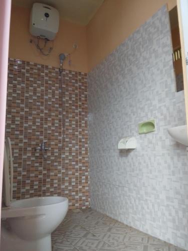 a bathroom with a toilet and a shower and a sink at Irene in Kelimutu