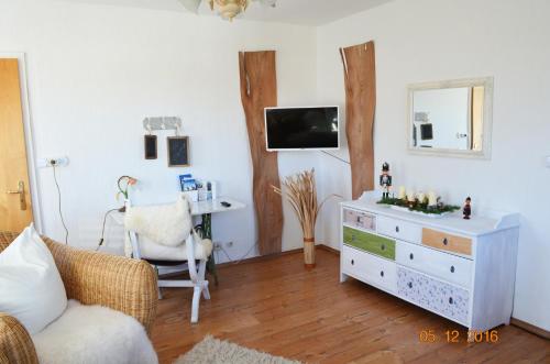 a living room with a white dresser and a desk at Die Dirndlkönigin in Grünenbach