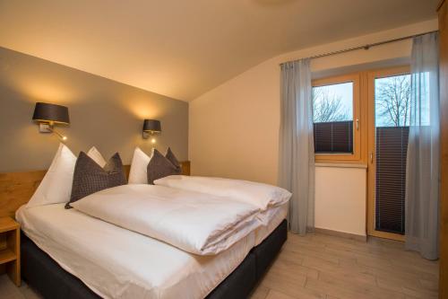 a bedroom with a large white bed and a window at Appartement Nanske in Kaprun