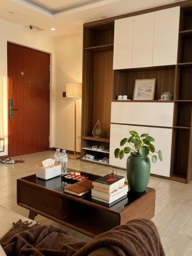 a living room with a coffee table with a potted plant at VEC Homes - Triển lãm VEC Đông Anh - Căn hộ 2 phòng ngủ in Dong Anh
