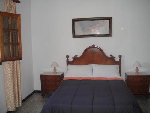a bedroom with a bed and two nightstands and a picture at Casa El Pino in Mogán