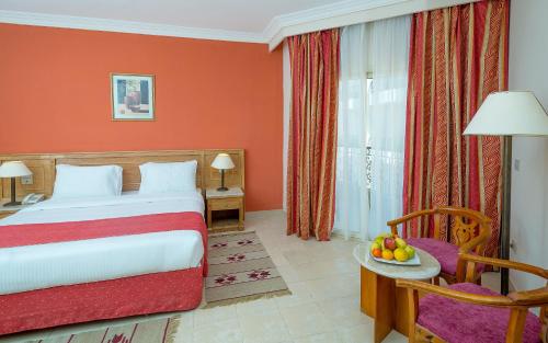 a hotel room with a bed and a chair at Hawaii Riviera Club Aqua Park - Families and Couples Only in Hurghada