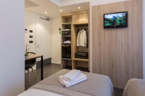 ブレッサノーネにあるTourist Hotelのベッド、デスク、壁掛けテレビが備わる客室です。