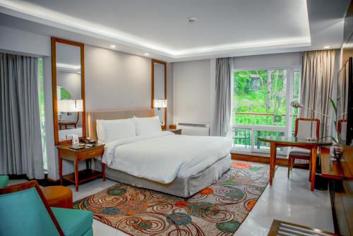a hotel room with a bed and a large window at Pearl Continental Hotel, Bhurban in Bhurban