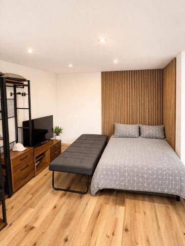 a bedroom with a bed and a flat screen tv at Balvi Ezera Street in Balvi