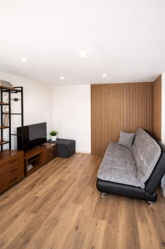 a living room with a couch and a flat screen tv at Balvi Ezera Street in Balvi