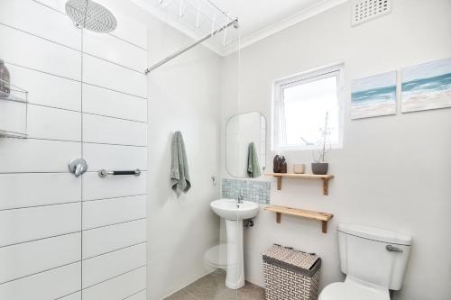 a white bathroom with a toilet and a sink at 32 Main Road in Struisbaai