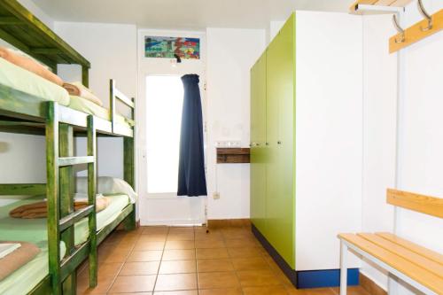 a dorm room with bunk beds and a window at Hostel albergue Paradiso in Hinojedo