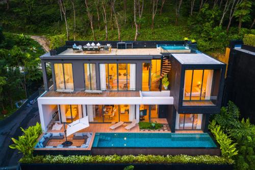 ラヤンビーチにあるAKRA Collection Layan - Hideaway Villasのプール付きの家の空撮写真
