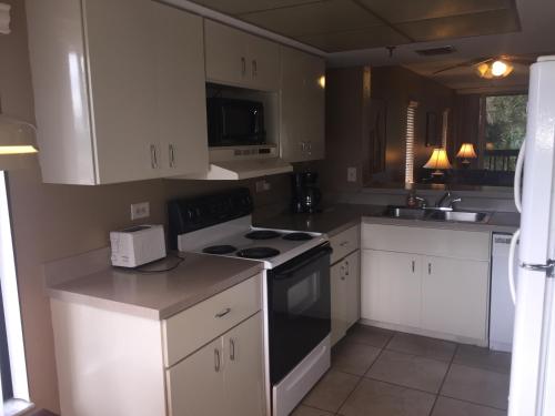 a kitchen with white cabinets and a stove top oven at Charlotte Bay Resort in Port Charlotte