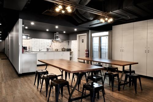 a kitchen with two tables and stools in a room at The Pod Sydney in Sydney